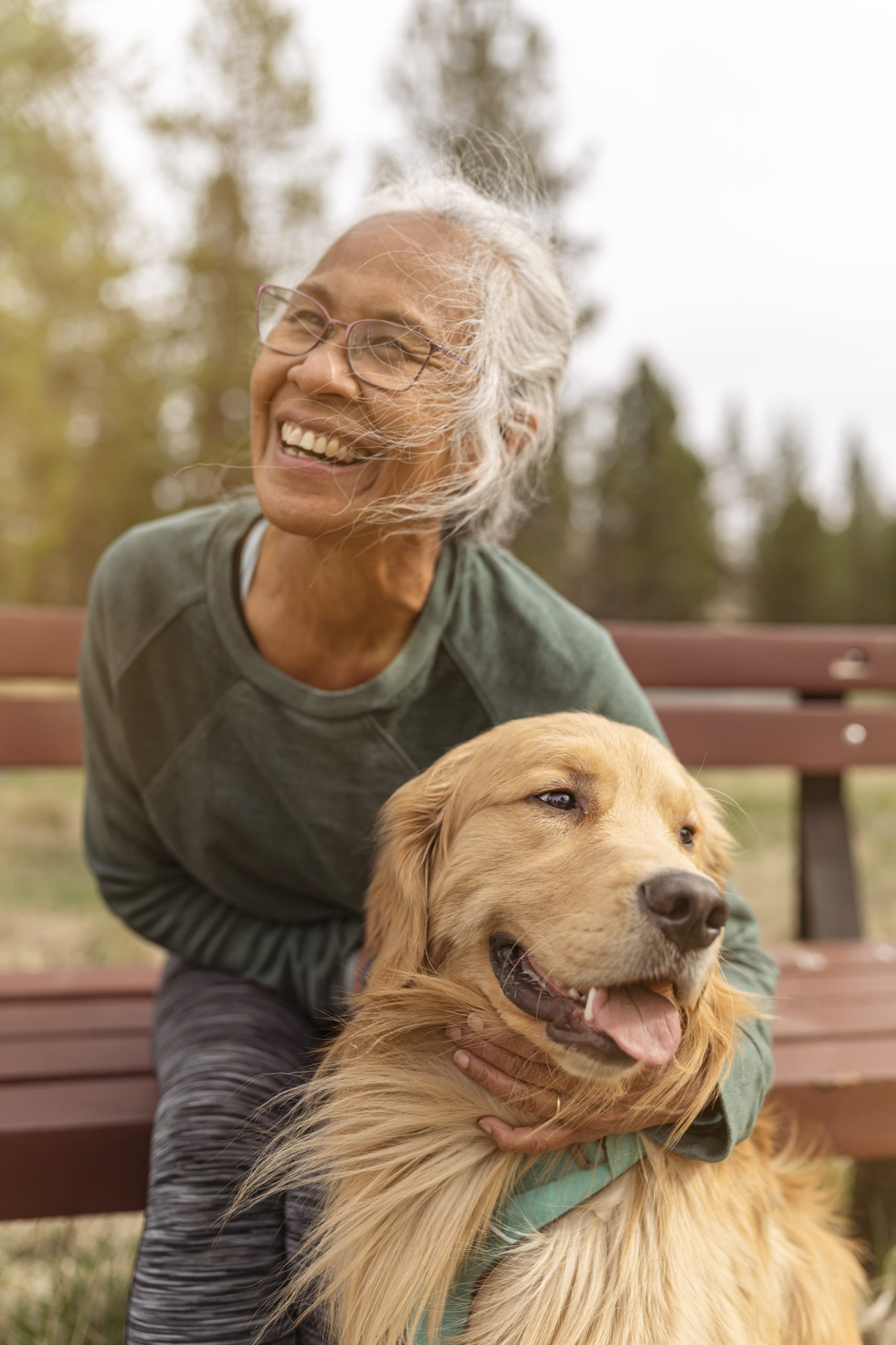 Active ethnic senior woman enjoying the outdoors with her pet dog